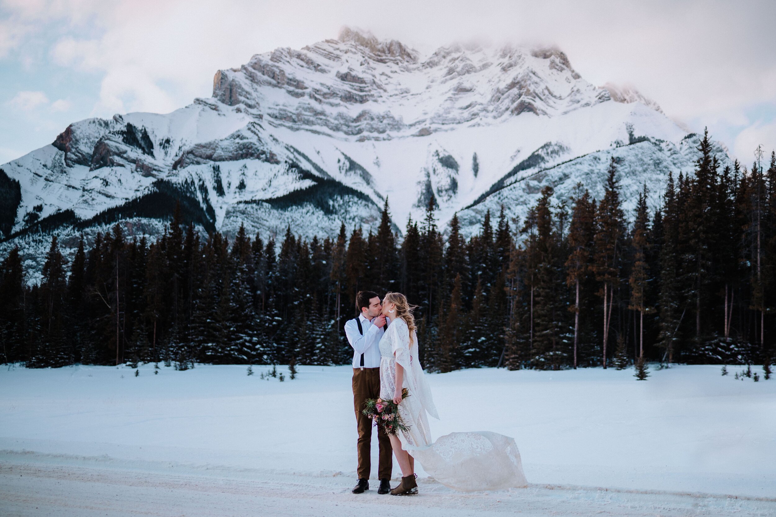 Elopement - couple kissing in front of mountains